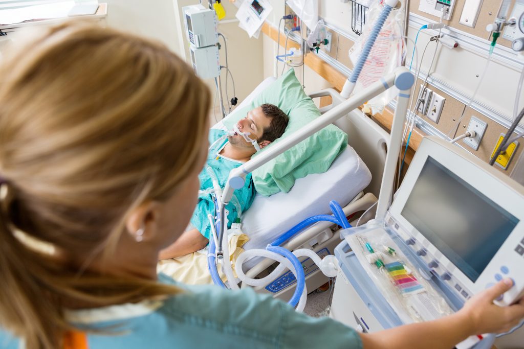Una enfermera vigila atentamente a un paciente dependiente de un respirador artificial