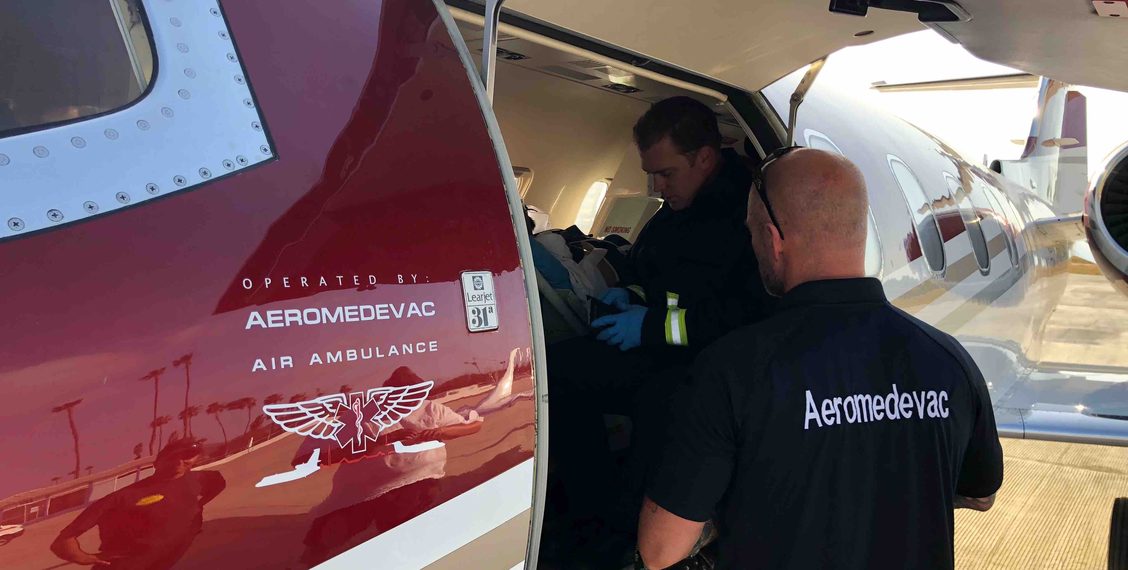 Aeromedevac Air Ambulance team members preparing a patient for a medical flight