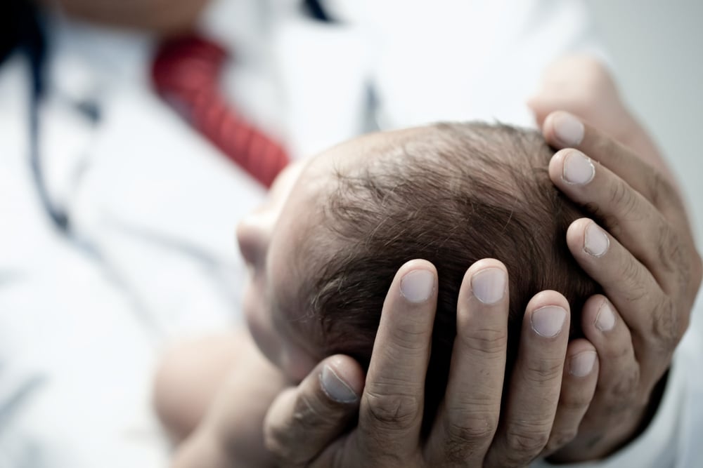 Pediatrician holding a beautiful newborn baby boy-1