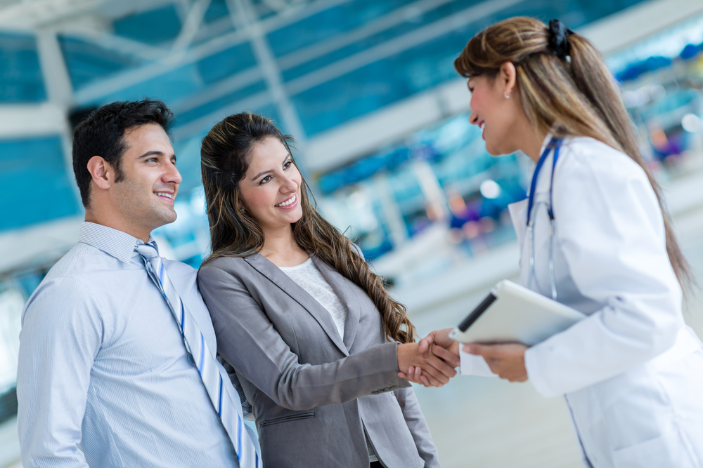 Doctor shaking hands with a couple at the hospital