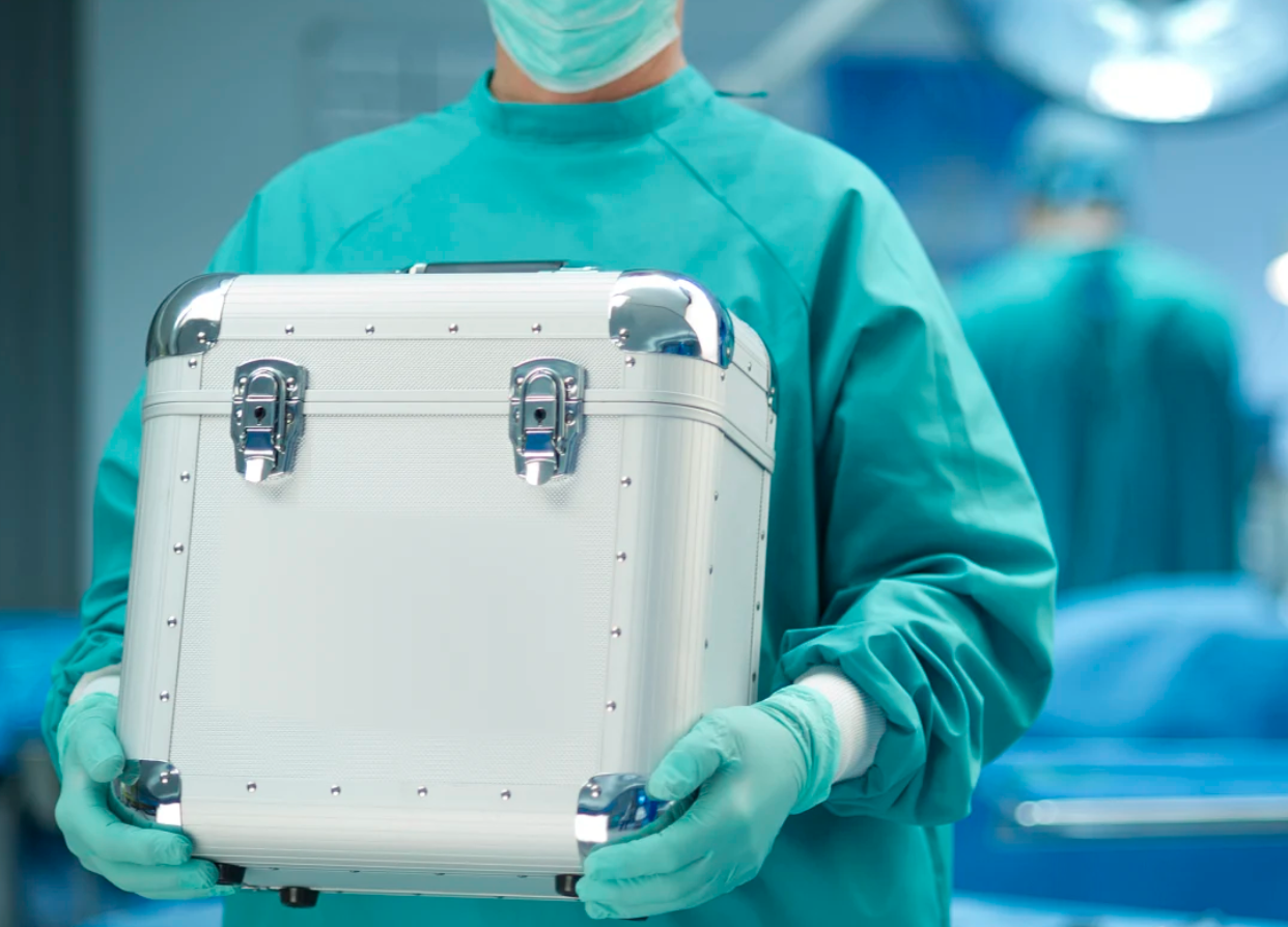 Un cirujano sostiene un órgano transportado por la ambulancia aérea Aeromedevac